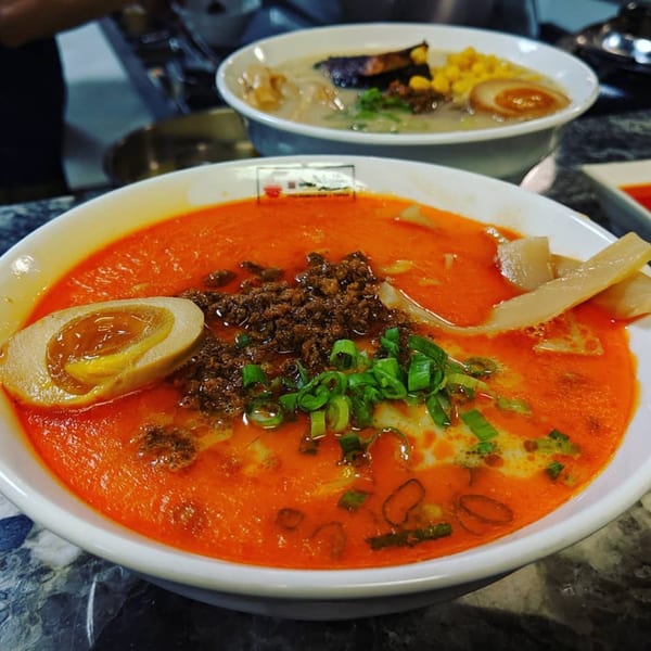 Two bowls of Itto Ramen, one with a rich red broth, egg, and ground meat, the other with a lighter broth.
