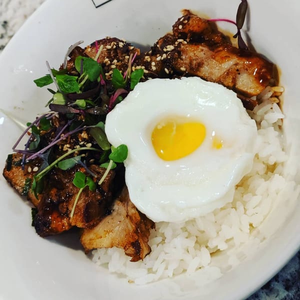 Itto Ramen Bar's Japanese tapas dish with rice, glazed pork belly, microgreens, and a fried egg.