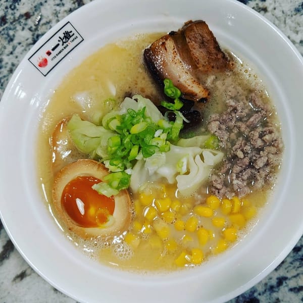 Itto Ramen bowl with pork belly, ground meat, soft-boiled egg, corn, cabbage, and green onions.